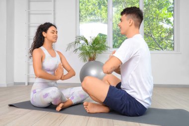 Genç çift birlikte spor salonunda meditasyon