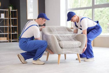 Doldurucular dolu koltukları odaya taşıyorlar.