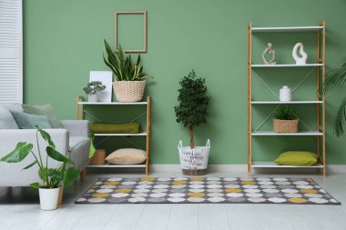 Oturma odasında rahat bir kanepe, heykel, saksı ve raf ünitesi var.