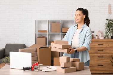 Depoda paket kutularıyla çalışan genç bir kadın.