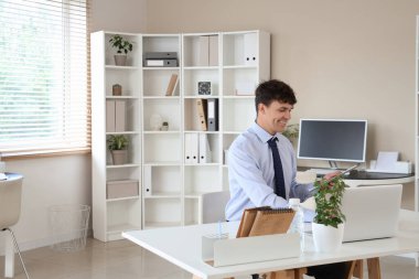 İş yerinde çalışan cep telefonu ve modern bilgisayarlı bir erkek muhasebeci.