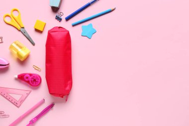 Pembe arka planda farklı kırtasiye malzemesi olan kalem kutusu. Üst görünüm