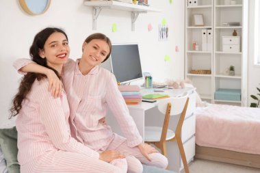 Yurt odasında sarılan kız öğrenciler.