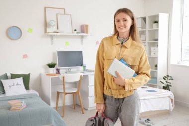 Yurt odasında kitap ve sırt çantası olan bir kız öğrenci.