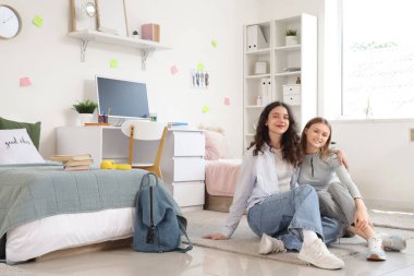 Yurt odasında yerde yatan kız öğrenciler.