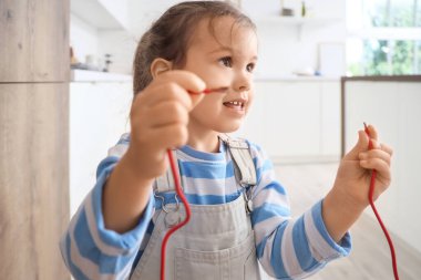 Mutfakta çıplak teli olan sevimli küçük bir kız, yakın plan. Tehlikedeki çocuk