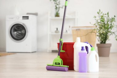 Evde kovayla paspas ve farklı temizlik malzemeleri var.