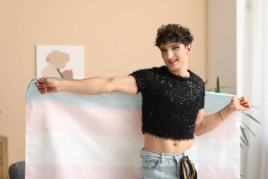 Evde bayrağı olan genç bir transseksüel kadın.