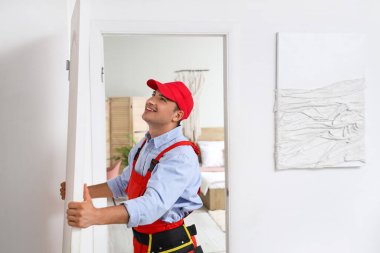 Erkek işçi eve kapı kuruyor.