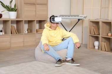 Genç çocuk yatak odasında VR gözlüğü kullanıyor.