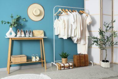 Mavi duvarın yanındaki beyaz elbiseli rafta.