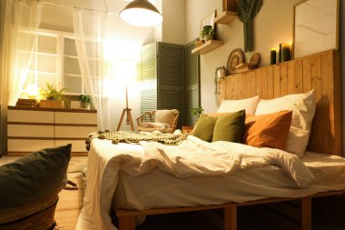 Şık bir yatak odası, rahat bir yatak odası ve geceleri parlayan lambalar.