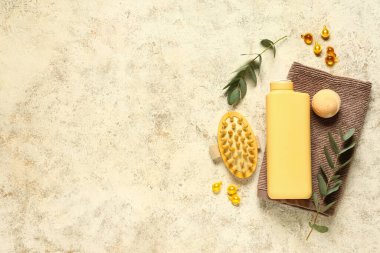 Hafif arkaplanda kozmetik ürünleri, spa aksesuarları ve okaliptüs dallarıyla kompozisyon