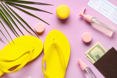 Şık parmak arası terlikleri, seyahat kozmetik ürünleri, pasaport ve arka planda palmiye yaprağı olan kompozisyon