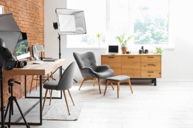 Modern stüdyoda bilgisayarlı, fotoğraf makineli ve ışıklandırma ekipmanlı fotoğraf işyeri