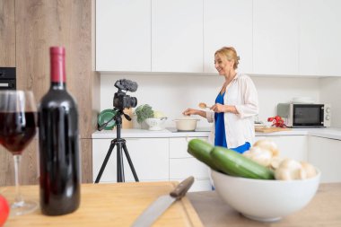 Mutfakta yemek pişirme kursuna giden olgun bir kadın.