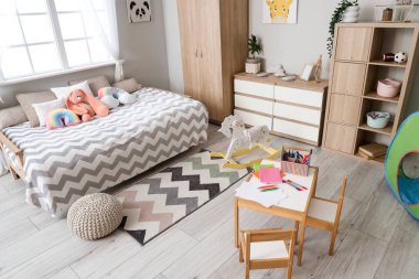 Yatak, dolap ve raf ünitesi olan çocuk odasının içinde.