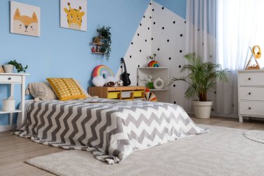 Yatak, raflar ve oyuncaklarla dolu bir çocuk odası.