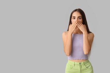Hafif arka planda diyasteyle şok olmuş genç bir kadın.
