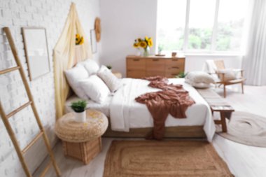 Açık renk yatak odası, rahat yatak ve güzel ayçiçekleri.