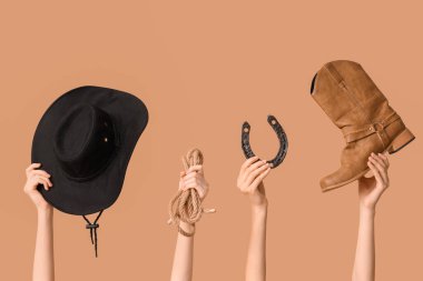 Arka planda kovboy aksesuarları olan kadın eller.