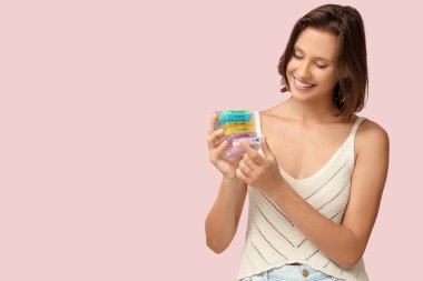 Pembe arka planda hap organizatörü olan güzel bir genç kadın.