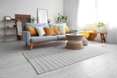 Kanepesi ve masası olan modern aydınlık oturma odasının içinde.