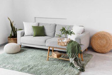 Gri kanepeli, yumuşak banklı ve puflu aydınlık oturma odasının içi