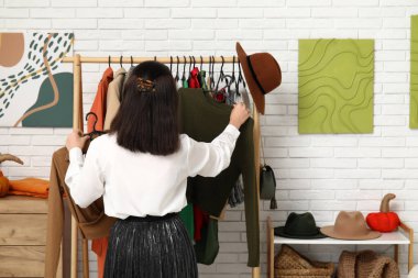 Soyunma odasında kıyafet seçen genç kadın