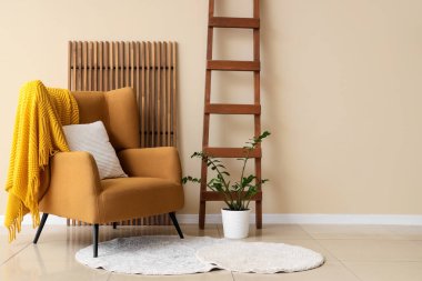 Oturma odasının içinde tahta merdiven, koltuk ve katlanır ekran var.