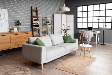 Ahşap merdiveni, kanepesi ve raf ünitesi olan oturma odasının içinde.