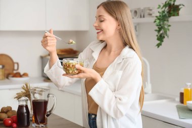 Mutfakta lezzetli okroshka olan genç bir kadın.