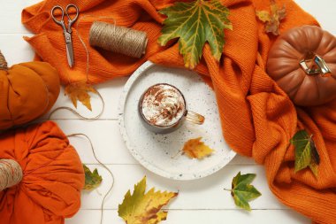 Kakao, eşarp ve beyaz ahşap arka planda yapraklarla sonbahar kompozisyonu