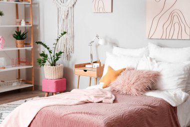 Ergen odasının içinde yatak, masa ve bitkiler var.