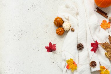 Şık, sıcak süveter, mumlar ve arka planda sonbahar dekoru olan kompozisyon