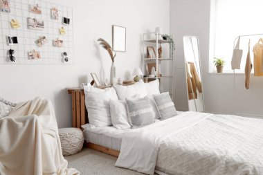 Işıl ışıl yatak odasının içinde, duvarında rahat bir yatak ve ruh hali tahtası asılı.