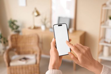 Evde boş cep telefonu kullanan kadın, yakın plan.