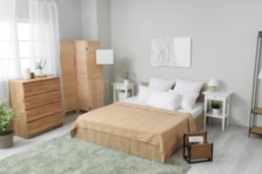 Rahat yatağı, dergileri ve ahşap mobilyaları olan şık bir yatak odası.