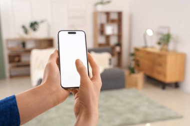Oturma odasında boş cep telefonu kullanan kadın, yakın plan.