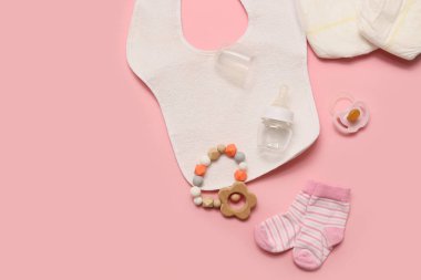 Pembe arka planda bebek şişesi ve aksesuarları olan kompozisyon