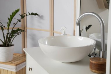 Açık banyodaki çekmecelerde seramik lavabo, yakın plan.