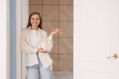 Anahtarları olan güzel genç bir kadın evinin kapısında bekliyor.