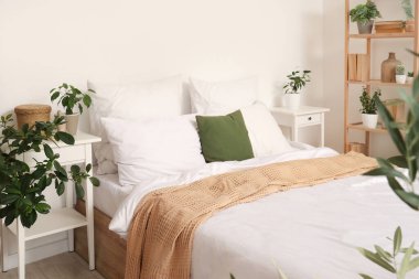 Büyük yataklı, komodinli ve birçok farklı çiçekli rahat bir yatak odası.