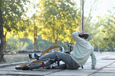 Sportif genç adam parkta bisikletinden düştü.