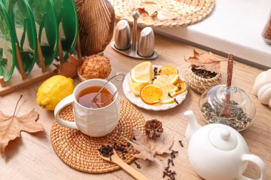 Çaydanlık, kekin yanında yeşil çay, masada limonlu ve sonbahar dekorlu bir tabak. Yakın çekim.