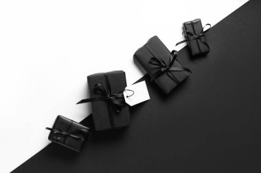 Renk arkaplanında boş kağıt etiketli hediye kutuları. Kara Cuma indirimi