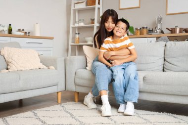 Genç anne ve küçük oğlu evde sarılıyorlar.