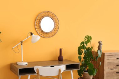 Çalışma odasının içinde lamba ve ayna olan bir yer.