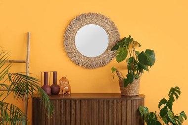 Oturma odasının iç tarafında çiçek ve ayna olan çekmeceler.