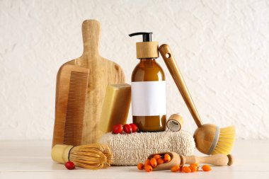 Doğal kozmetik ürünleri, spa aksesuarları ve hafif ahşap masada yabani böğürtlenlerle kompozisyon